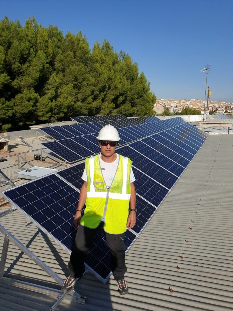 Energías Renovables Ingeniero con caso y chaleco encima de un tejado de una instalación solar de autoconsumo